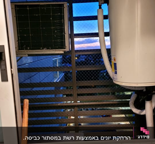 יחידת מזגן ורשת מתכת על חלון